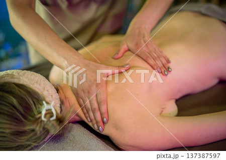 Professional lady masseuse making pain relief massage procedure on upper body for woman client. 137387597