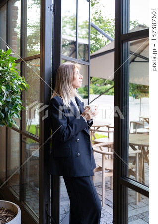 Relaxed pensive businesswoman small business owner drinking coffee and thinking about new goals. 137387601