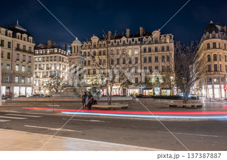 Lyon, france. December 27, 2023. Place des jacobins fountain and classic architecture at night, long exposure capturing car light trails and urban activity Lyon, france. December 27, 2023. Place des jacobins fountain and classic architecture at night, long exposure capturing car light trails and urban activity 137387887