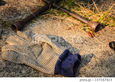 Old dirty worker gloves lying on ground 137387923