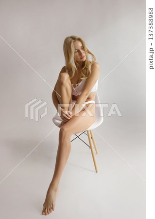 Beautiful woman with smooth legs sitting on chair after hair removal, skin care and epilation beauty concept 137388988