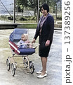 Vintage portrait of a mother and baby in a stroller. Young woman on a walk with a small child. Retro 1968. 137389256