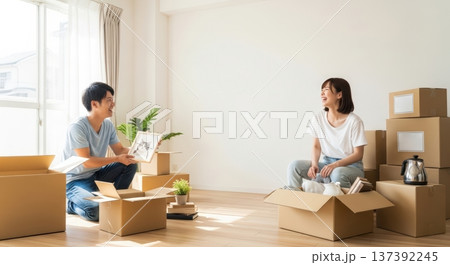 明るい部屋で新生活の引っ越し作業をする若い男女　入学・新社会人・新生活イメージ（文字スペースあり） 137392245