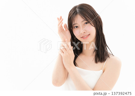 白背景でスキンケアをする女性のビューティーイメージ 白背景でスキンケアをする女性のビューティーイメージ 137392475