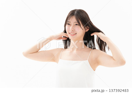 白背景でスキンケアをする女性のビューティーイメージ 137392483