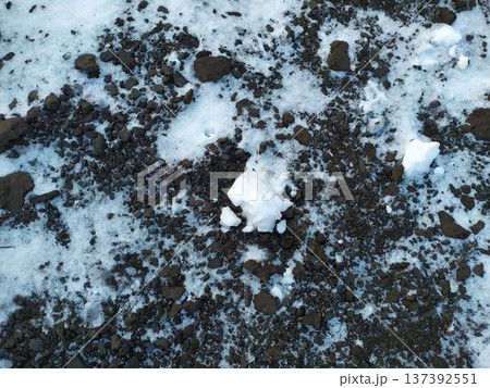 Melting snow patches on dark earth. Winter soil texture background 137392551