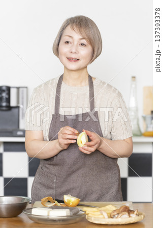 キッチンで野菜を切り料理の下ごしらえをするシニア女性 キッチンで野菜を切り料理の下ごしらえをするシニア女性 137393378
