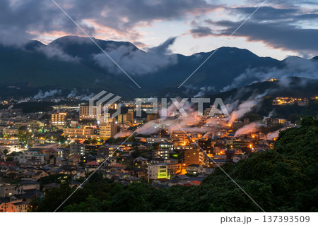 Beppu town with smoke of hot spring bath ryokan at dusk, Oita 137393509