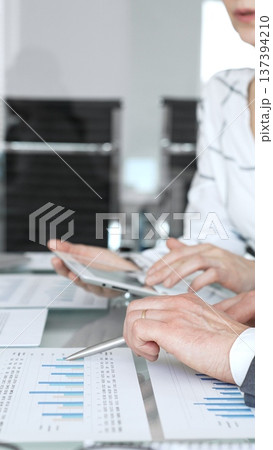 Business person's hands holding a pen, reviewing and signing a legal contract or agreement document during an important office meeting, finalizing a deal Business person's hands holding a pen, reviewing and signing a legal contract or agreement document during an important office meeting, finalizing a deal 137394210