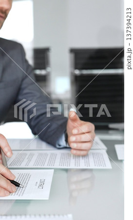 Business people engaging in a meeting, discussing important contract terms and financial agreements, clarifying legal details, signing documentation, and collaborating on corporate projects Business people engaging in a meeting, discussing important contract terms and financial agreements, clarifying legal details, signing documentation, and collaborating on corporate projects 137394213