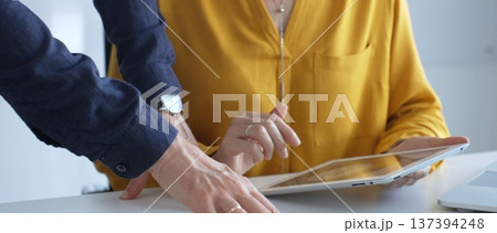 Business colleagues are analyzing data on a digital tablet and printed documents, working together on a project in the office. Business people concept Business colleagues are analyzing data on a digital tablet and printed documents, working together on a project in the office. Business people concept 137394248