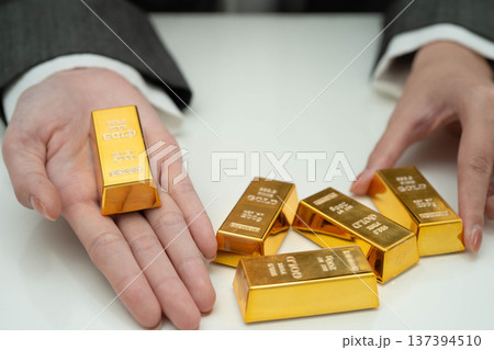 Asian woman holding gold bar in finance business. Asian woman holding gold bar in finance business. 137394510
