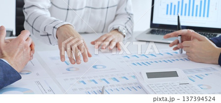 Business people discussing financial data and analyzing market trends during a corporate meeting, reviewing strategy with charts and graphs in the office 137394524
