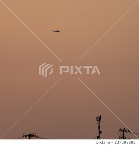 夕焼け空のヘリコプターと電線 137395693