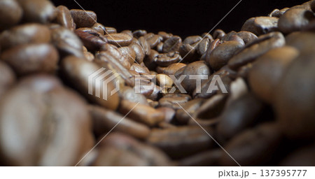Coffee beans are spread out on a surface in a close-up view showing their texture and shape Coffee beans are spread out on a surface in a close-up view showing their texture and shape 137395777