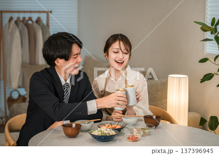 マイホームのダイニングテーブルで食事,晩酌をする若いアジア人夫婦,カップル 137396945