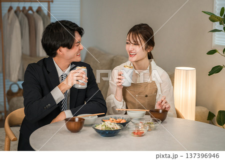 マイホームのダイニングテーブルで食事,晩酌をする若いアジア人夫婦,カップル 137396946