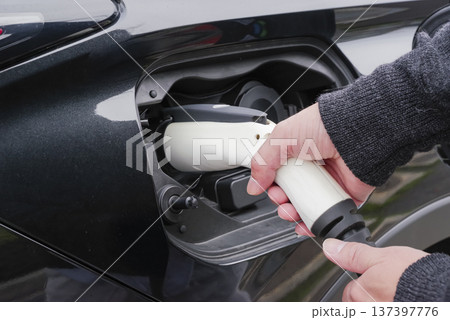 EV充電プラグを接続するドライバーの手元 137397776