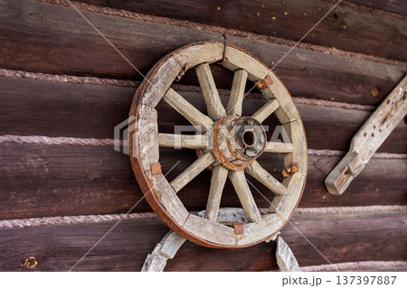Aged wagon wheel. Closeup of corroded spokes and peeling paint on weathered wagon wheel Aged wagon wheel. Closeup of corroded spokes and peeling paint on weathered wagon wheel 137397887