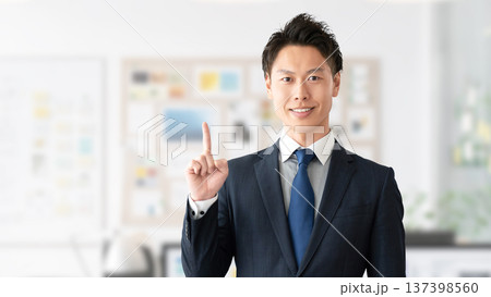 人差し指を立てて案内する男性ビジネスマン 137398560