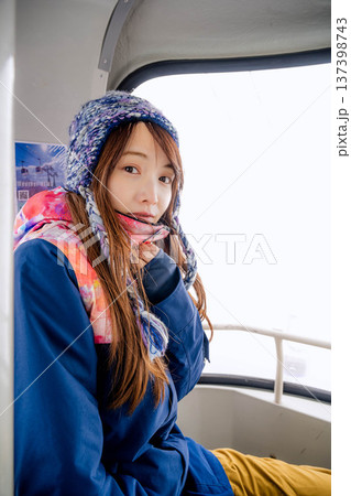 スキー場でゴンドラに乗っている若い女性 スキー場でゴンドラに乗っている若い女性 137398743