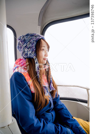 スキー場でゴンドラに乗っている若い女性 137398746