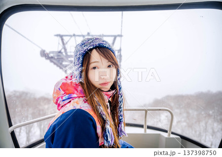 スキー場でゴンドラに乗っている若い女性 137398750