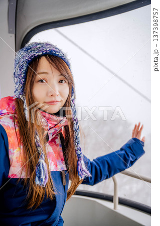 スキー場でゴンドラに乗っている若い女性 スキー場でゴンドラに乗っている若い女性 137398757