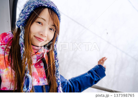 スキー場でゴンドラに乗っている若い女性 スキー場でゴンドラに乗っている若い女性 137398765