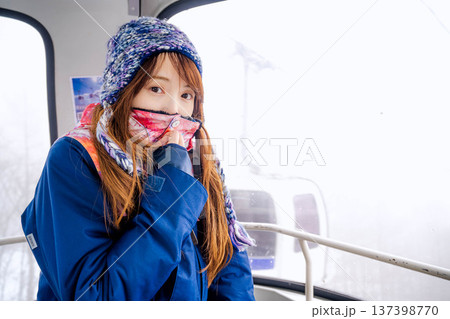 スキー場でゴンドラに乗っている若い女性 137398770