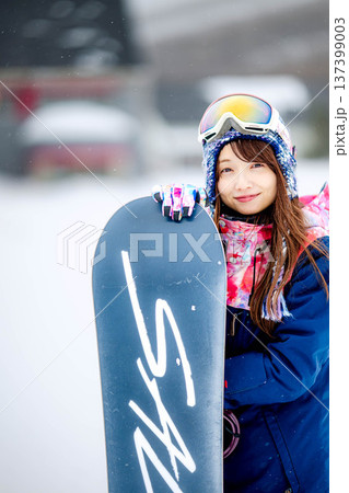 スキー場のゲレンデでウィンタースポーツのスノーボードを楽しむ若い女性 スキー場のゲレンデでウィンタースポーツのスノーボードを楽しむ若い女性 137399003