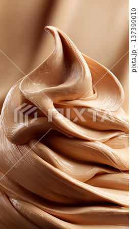 Closeup of smooth, thick, wavy beige cream swirls on soft background showing luxury texture concept of a liquid foundation Closeup of smooth, thick, wavy beige cream swirls on soft background showing luxury texture concept of a liquid foundation 137399010