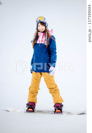 スキー場のゲレンデでウィンタースポーツのスノーボードを楽しむ若い女性 137399084