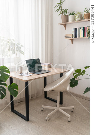 Minimalist study room featuring wooden desk, laptop, white ergonomic chair, green house plants, creating remote work environment Minimalist study room featuring wooden desk, laptop, white ergonomic chair, green house plants, creating remote work environment 137399441