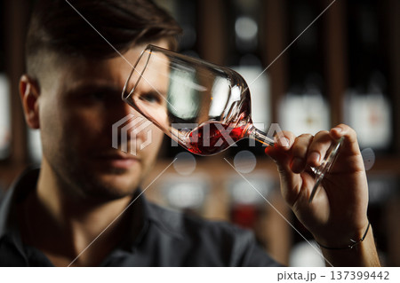 Bokal of red wine on background, male sommelier appreciating drink 137399442