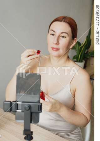 Woman creating beauty vlog applying skincare serum at home Woman creating beauty vlog applying skincare serum at home 137399509