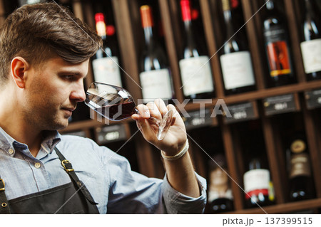 Bokal of red wine on background, male sommelier appreciating drink 137399515