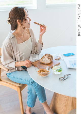 ダイニングテーブルで朝食をとる若いアジア人女性 ダイニングテーブルで朝食をとる若いアジア人女性 137400598