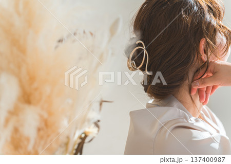 西陽の当たるリビングにいる女性とドライフラワー（モデル,ファッション,光,影） 137400987