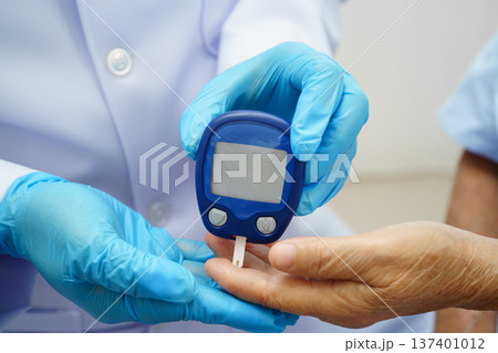 Asian doctor using digital glucose meter for check sample blood sugar level to treatment diabetes. 137401012