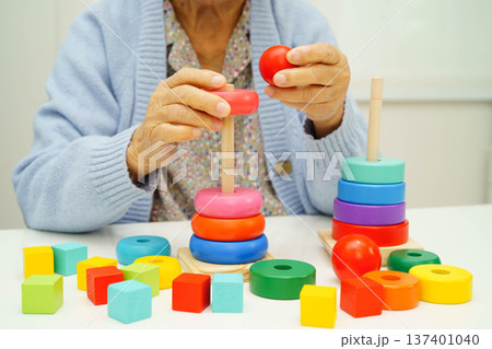 Asian elderly woman playing enhancing skill board game. Asian elderly woman playing enhancing skill board game. 137401040