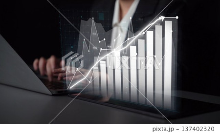 Business professional analyzing data trends on a laptop, showcasing graphs, charts, and financial growth in a modern workspace with focus on technology Copula 137402320