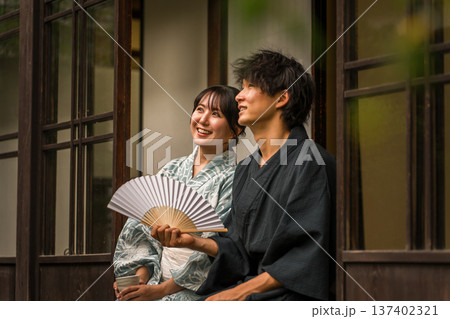 旅館,古民家,日本家屋の縁側で景色,空を眺める浴衣姿のカップル,夫婦 旅館,古民家,日本家屋の縁側で景色,空を眺める浴衣姿のカップル,夫婦 137402321