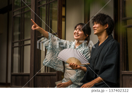 旅館,古民家,日本家屋の縁側で景色,空を眺める浴衣姿のカップル,夫婦 137402322