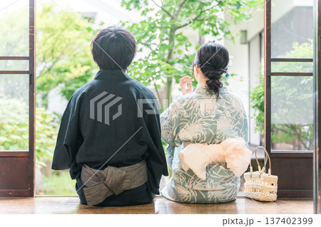 日本家屋の縁側でくつろぐ浴衣姿の夫婦,カップル 日本家屋の縁側でくつろぐ浴衣姿の夫婦,カップル 137402399