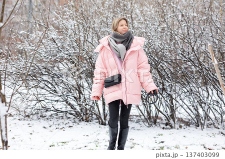 Woman enjoying music with headphones outdoors in winter 137403099
