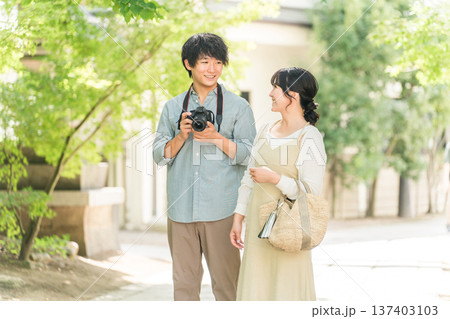 旅行先で一眼レフカメラで写真を撮る男性と女性 137403103