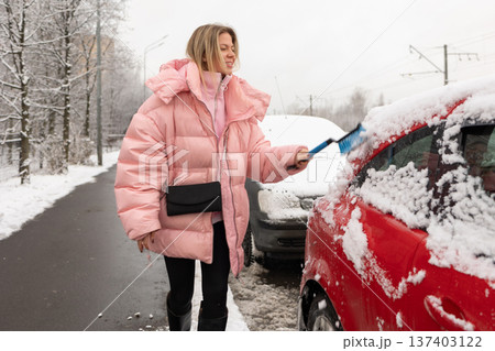 Winter car snow cleaning in city 137403122