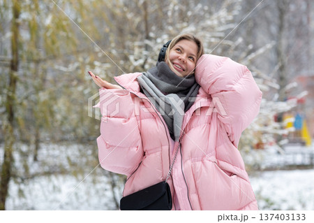 Woman enjoying music with headphones outdoors in winter Woman enjoying music with headphones outdoors in winter 137403133