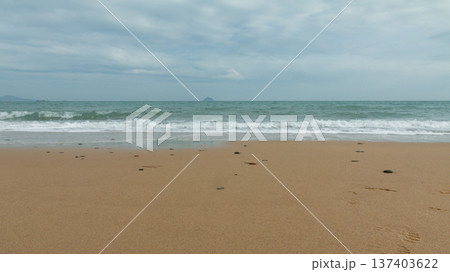 Gentle ocean waves reaching sandy beach Gentle ocean waves reaching sandy beach 137403622